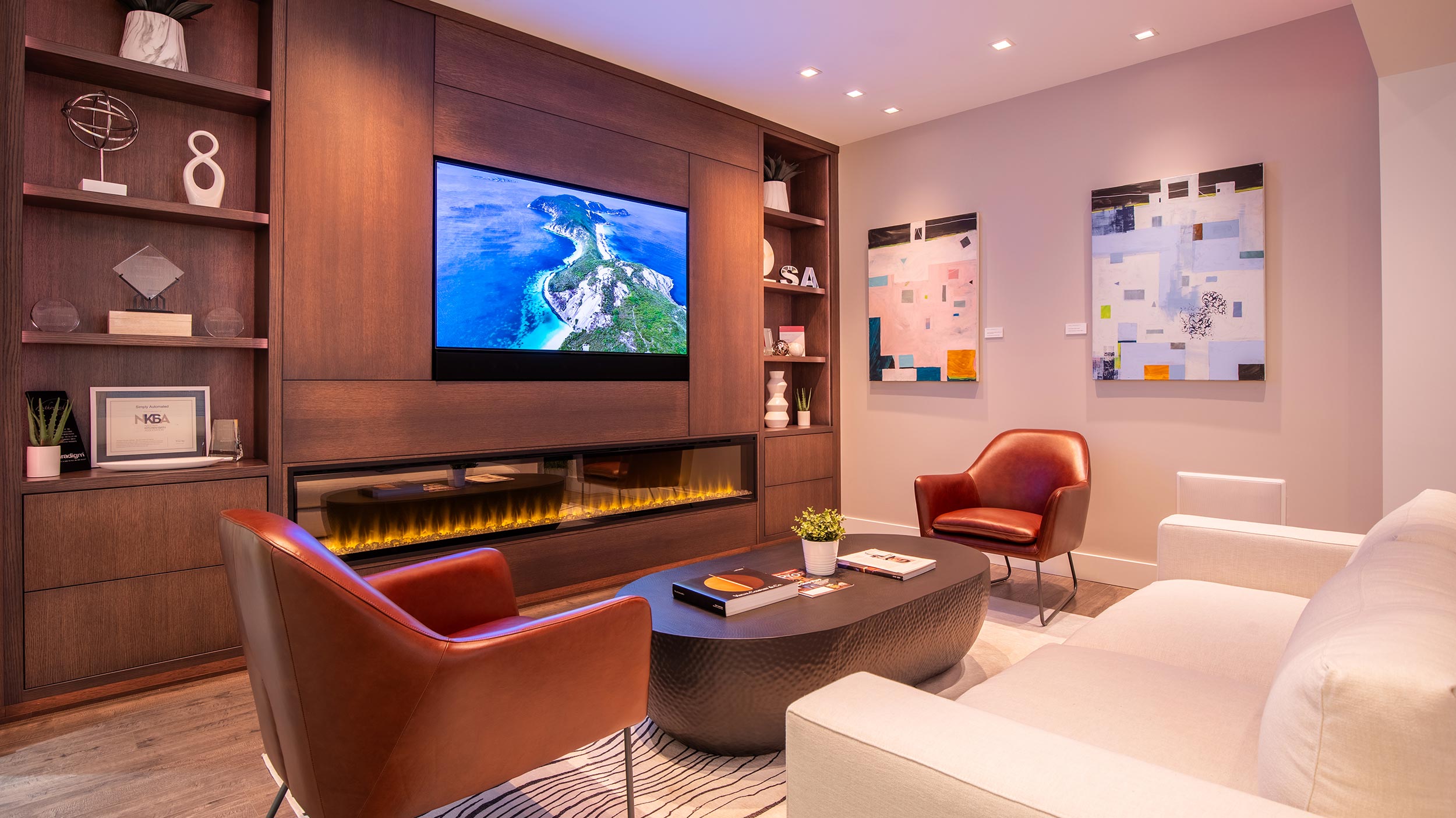 Cozy living room with a built-in entertainment center, large screen TV, modern fireplace, and stylish decor.